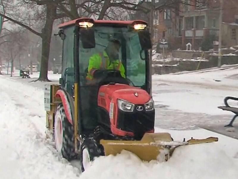 sidewalk tractor plowing snow